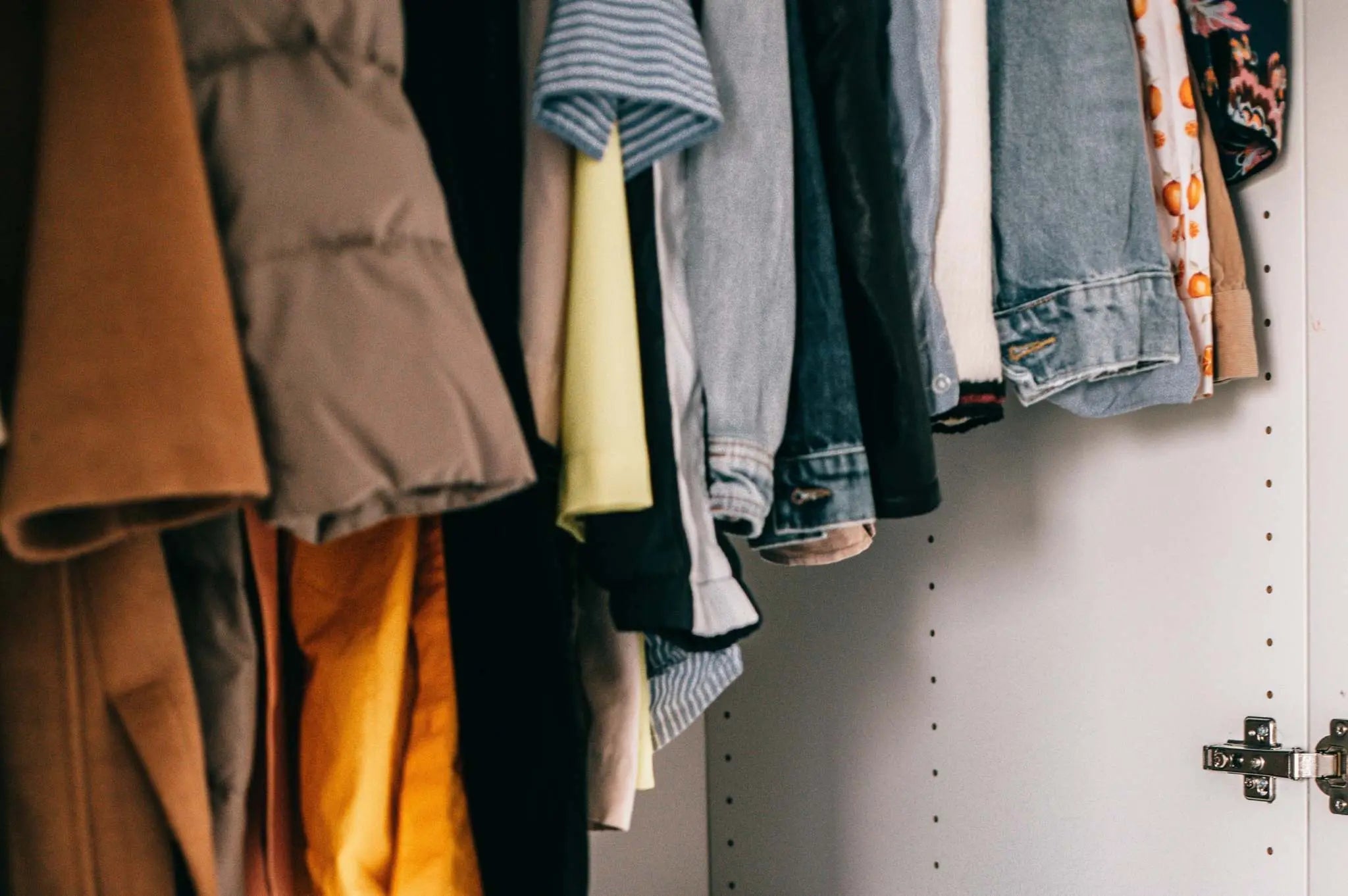 Closet with a variety of clothes hanging, illustrating an ethical and sustainable wardrobe concept.