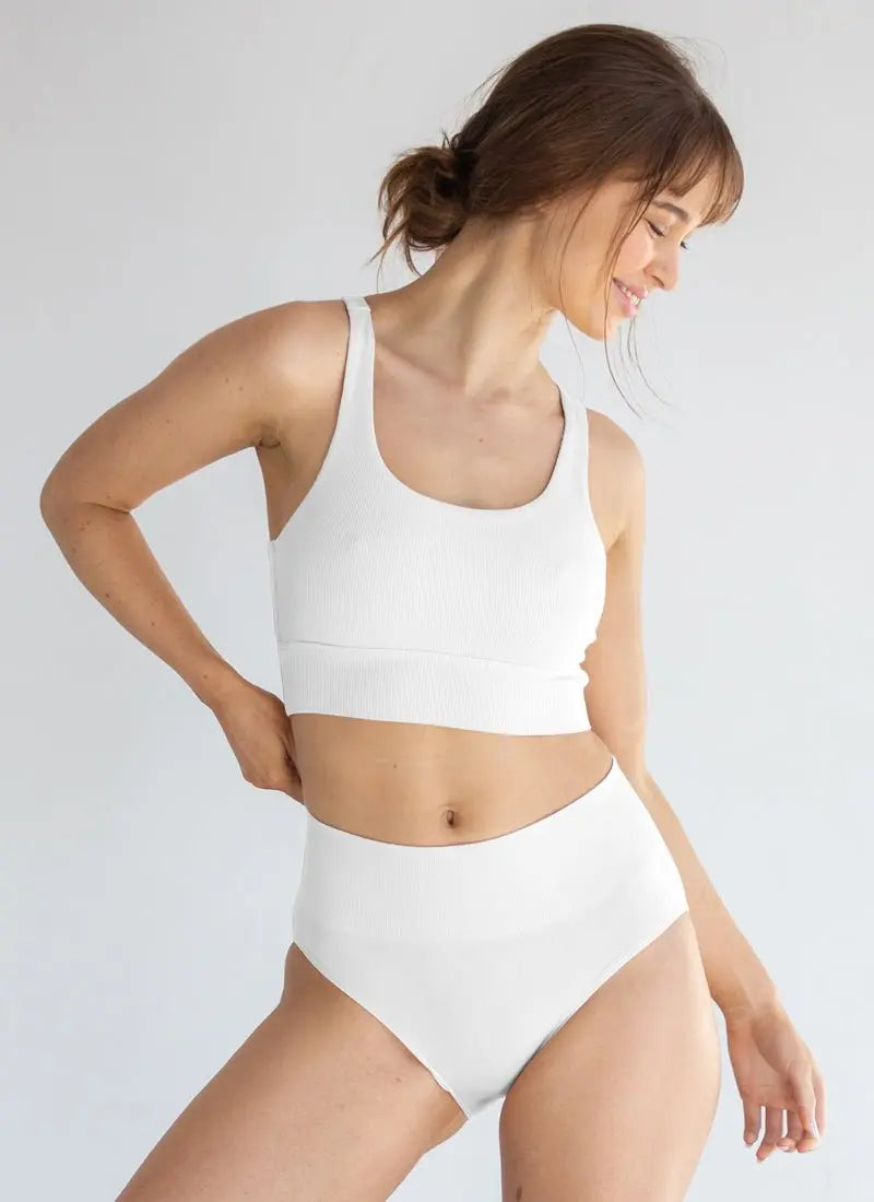 Woman wearing white seamless underwear set demonstrating comfort and sustainability benefits of seamless manufacturing for reducing textile waste