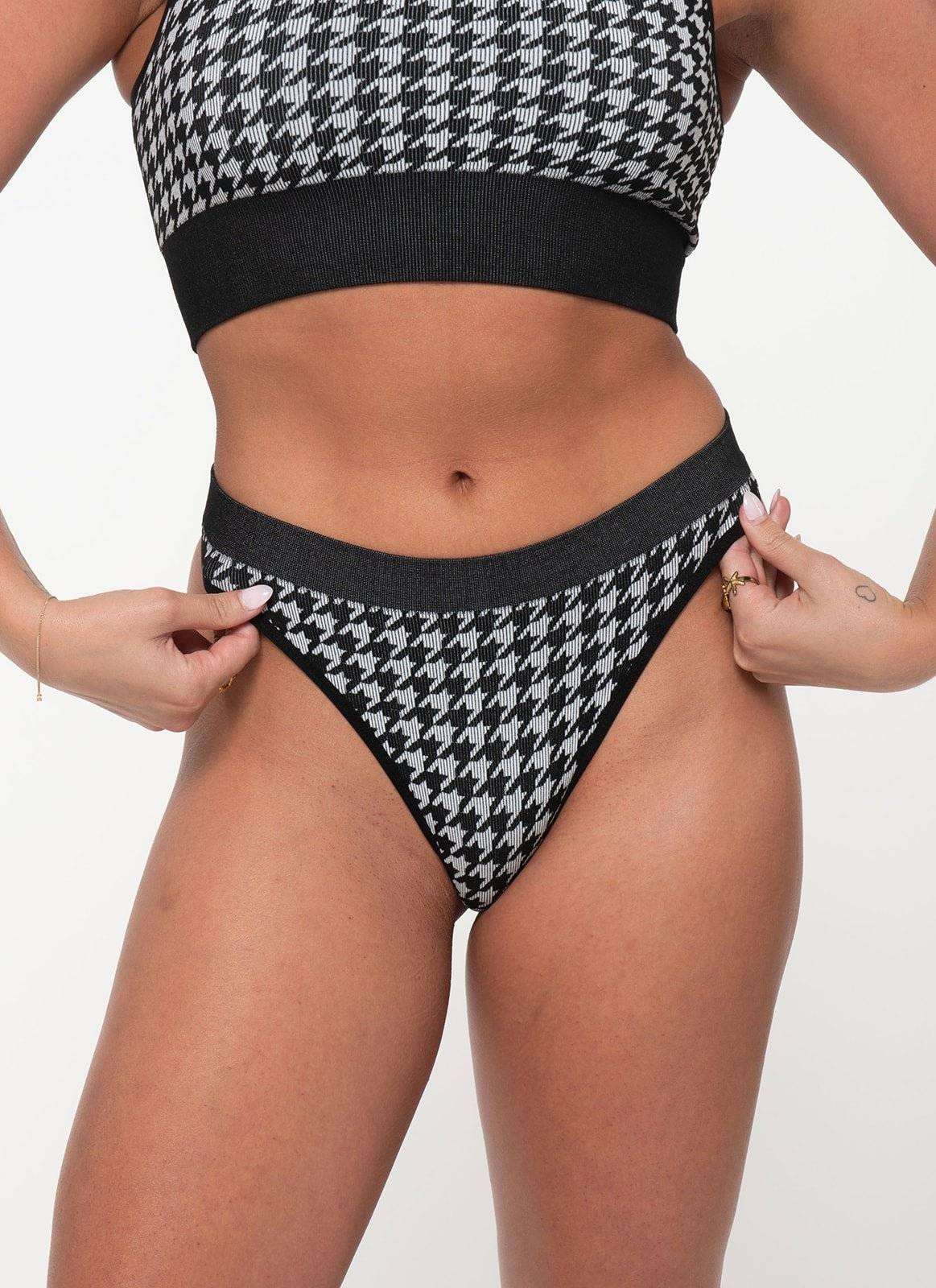 Woman wearing black and white houndstooth patterned cheeky G-string underwear with ribbed eco-fabric and no-dig waistband.