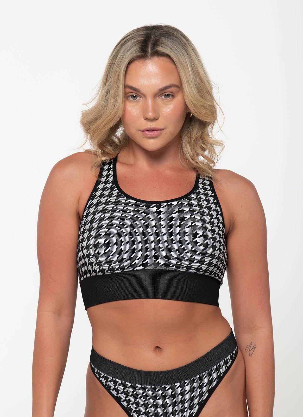 woman wearing black and white houndstooth racerback tank top and matching underwear set