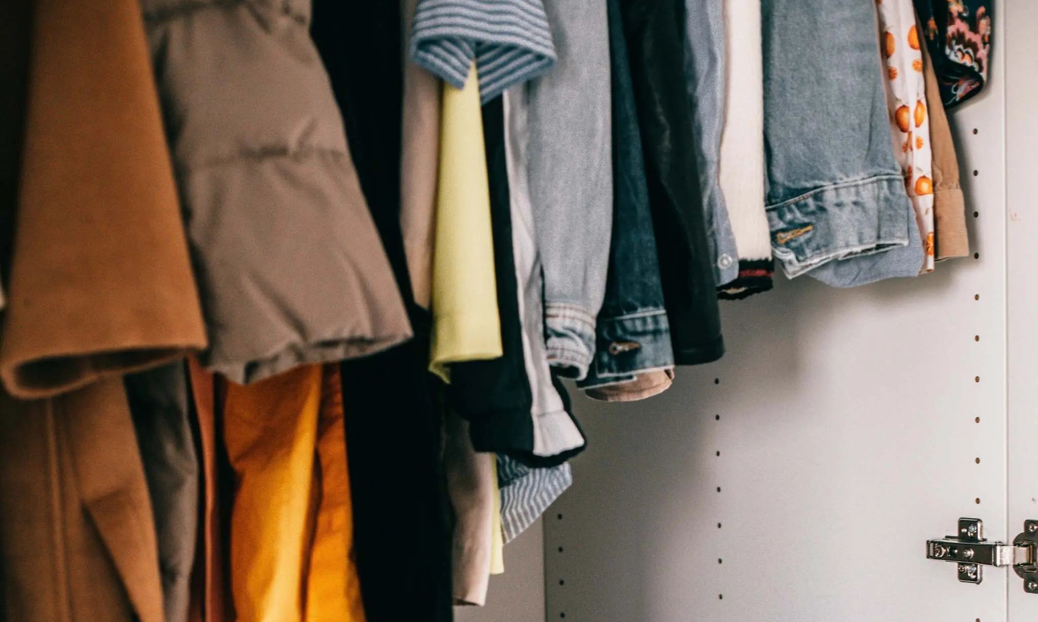 Closet with a variety of clothes hanging, illustrating an ethical and sustainable wardrobe concept.