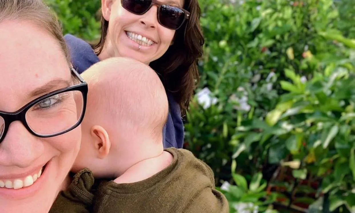 Family embracing sustainable living outdoors at a plant nursery with greenery in the background