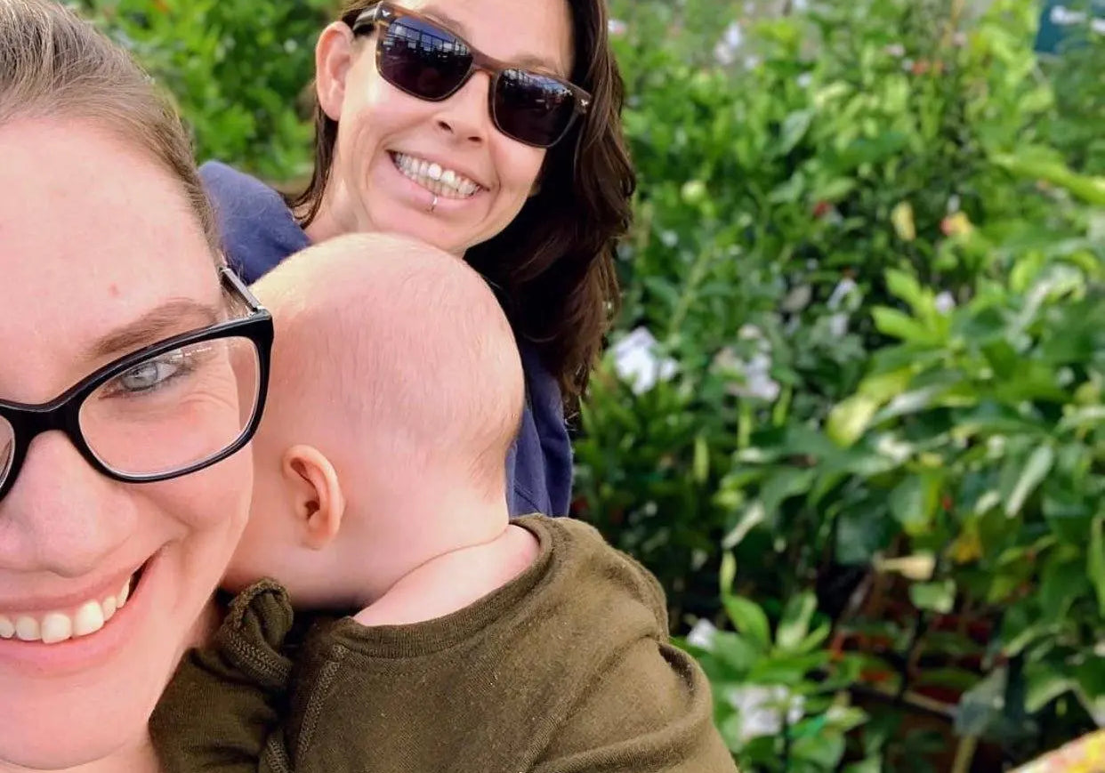 Family embracing sustainable living outdoors at a plant nursery with greenery in the background