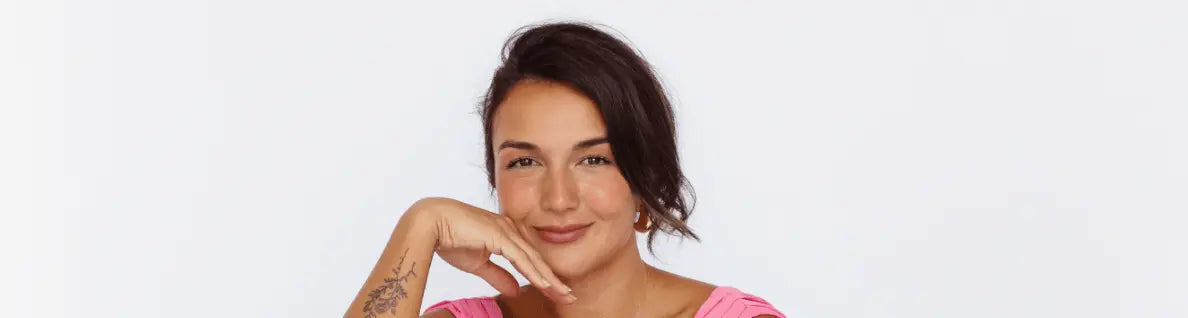 Portrait of Revie Jane founder of CrossFit Babes Miami wearing pink top and smiling against white background